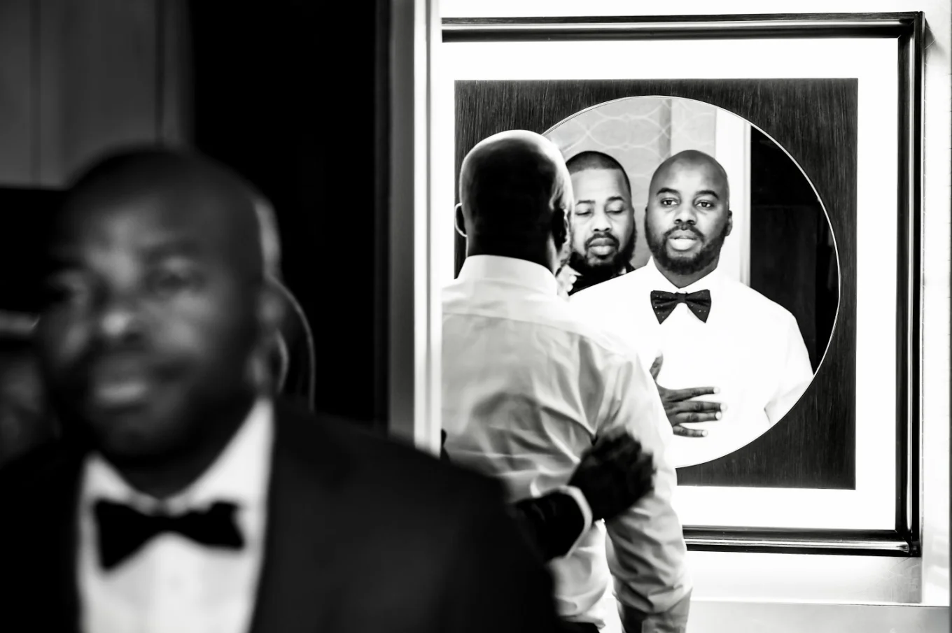 The groom and best man in from of the mirror getting ready before Calgary Wedding Ceremony.