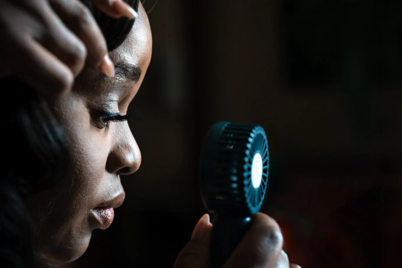Bride uses a small electric fan during hot Calgary Wedding Day.