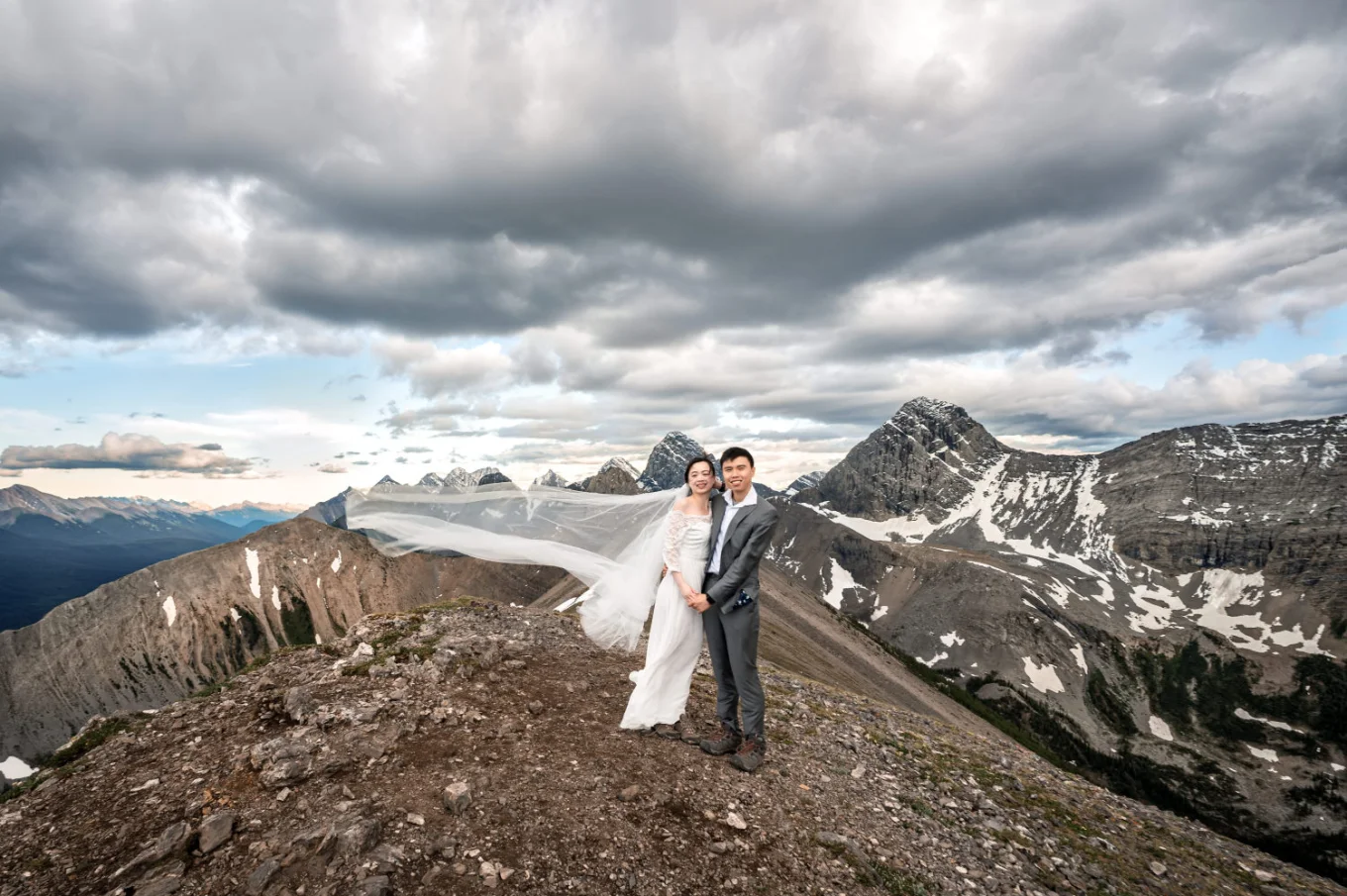Bride and groom in a hug looking in the camera in the Canadian Rockies.