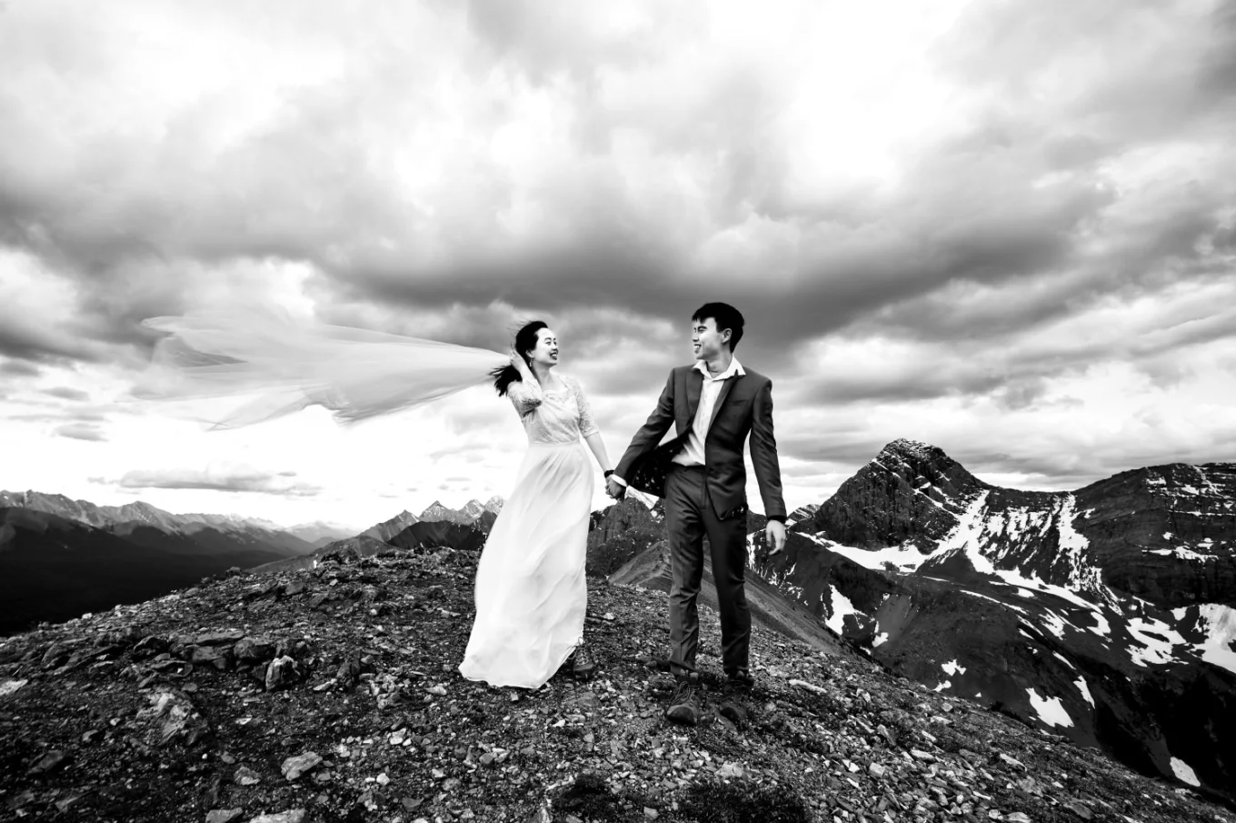 Newlyweds walk at the ridge on the mountain in Banff.
