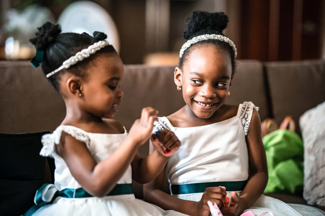Flower girls laughing to each other before the wedding ceremony.
