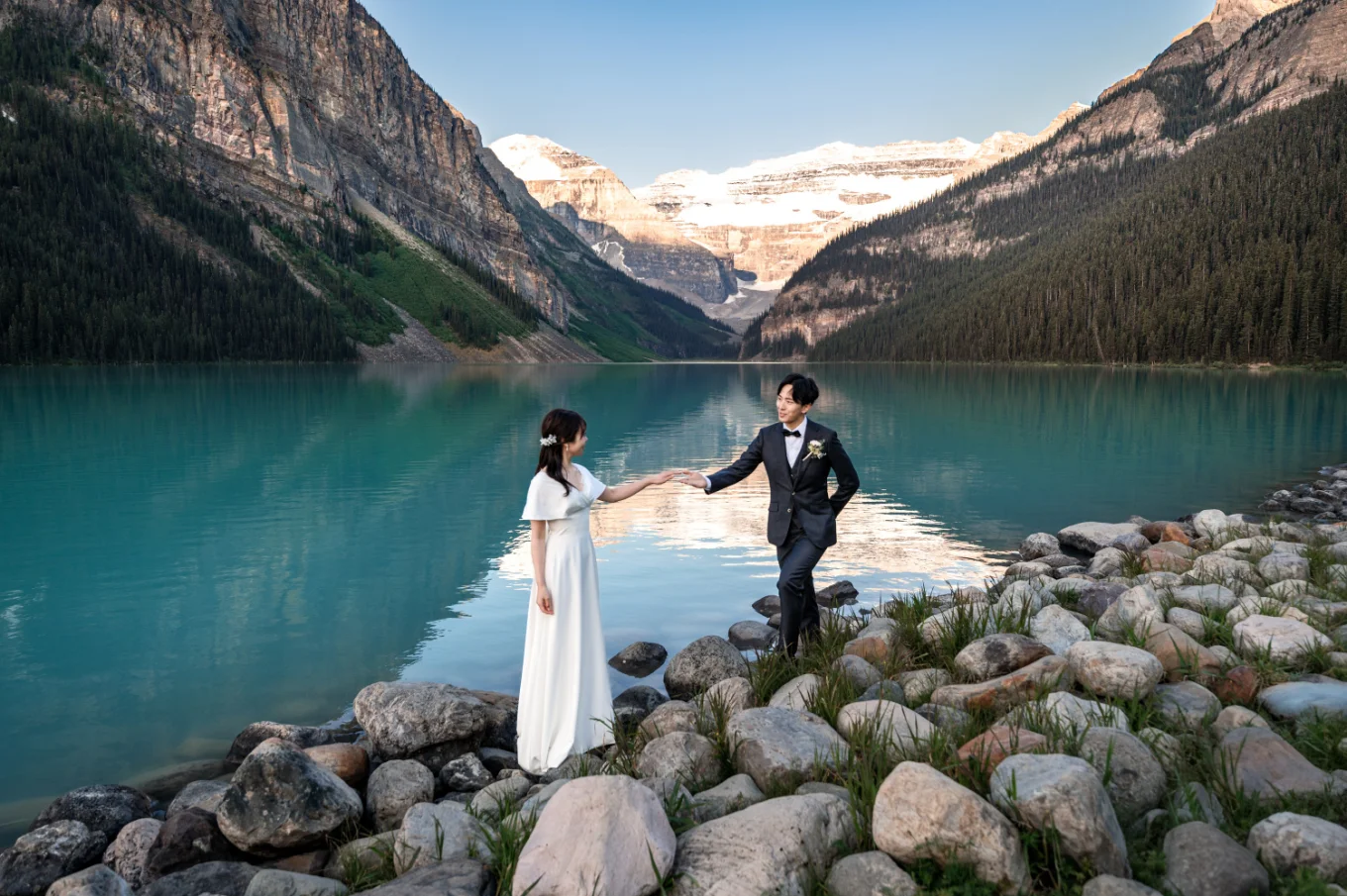 Groom holds the bride's hand with the elegance.