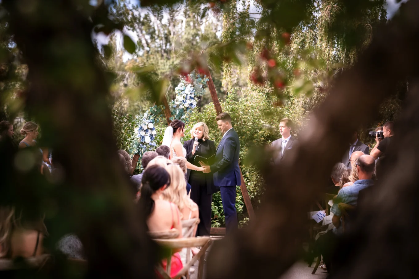 Photograph through the tree of the wedding ceremony in Calgary.