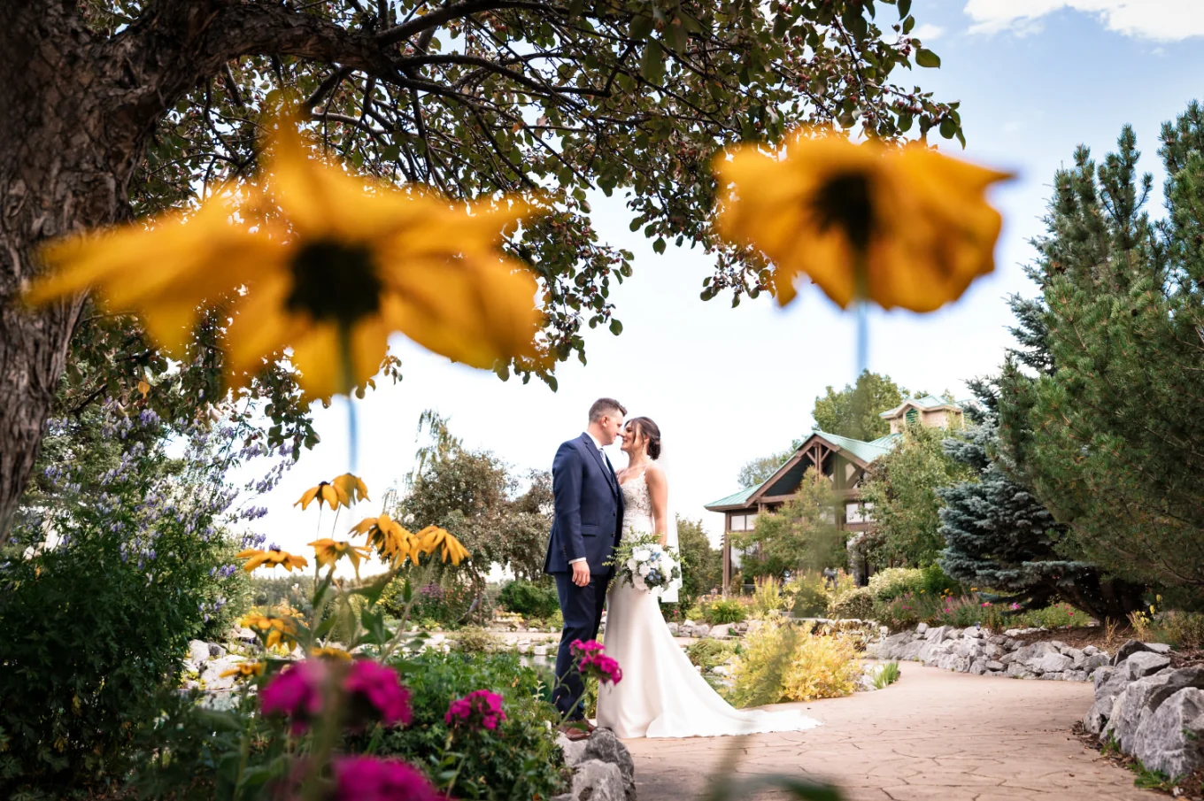 Photograph of the newlyweds in between the yellow flowers.