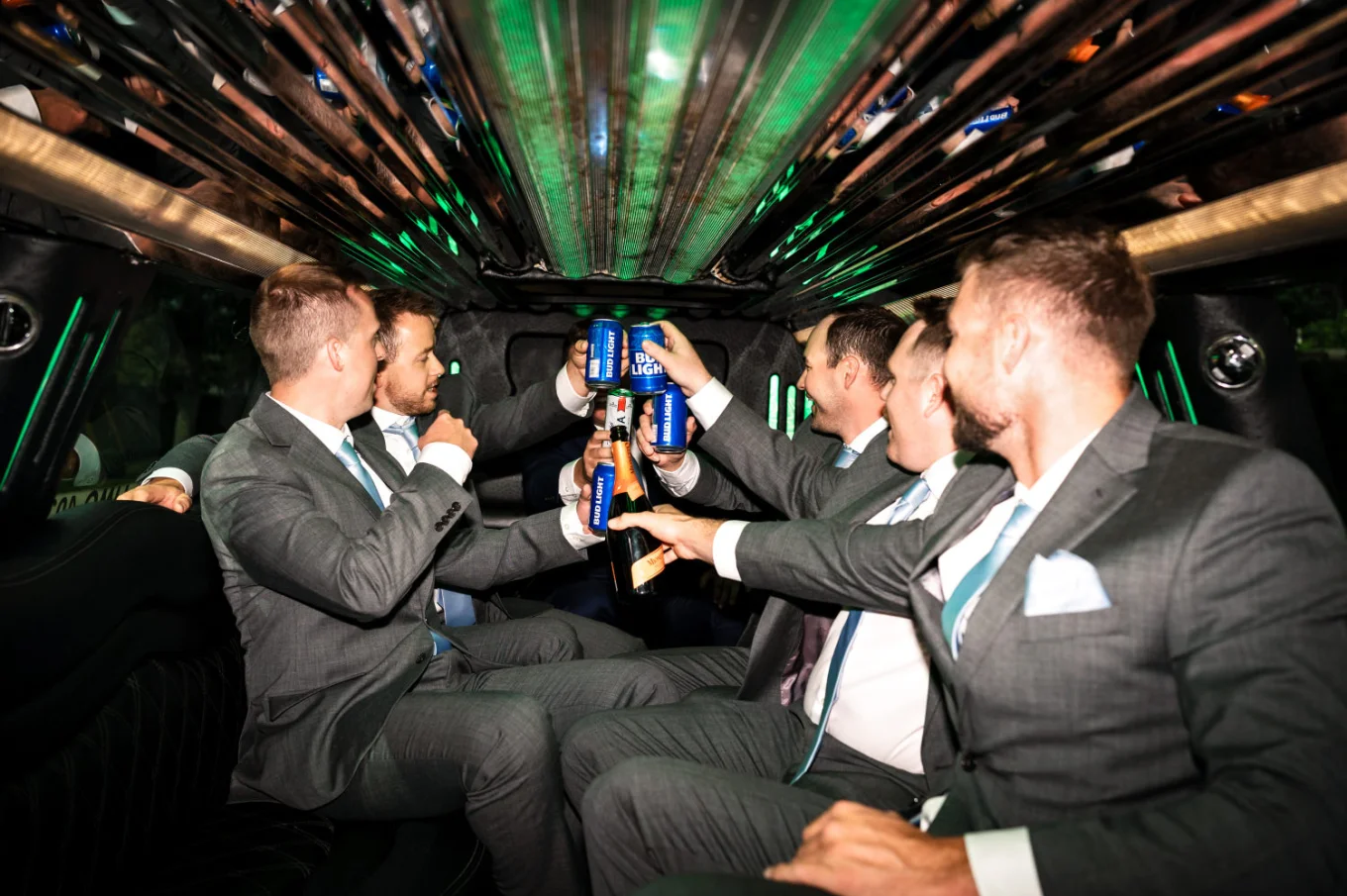 Wedding party in the limo drinking beers.