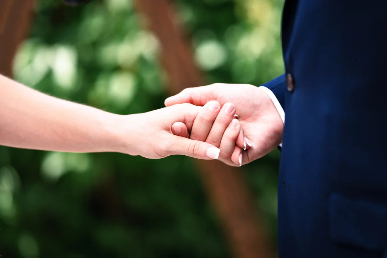 Groom holds the bride's hand.