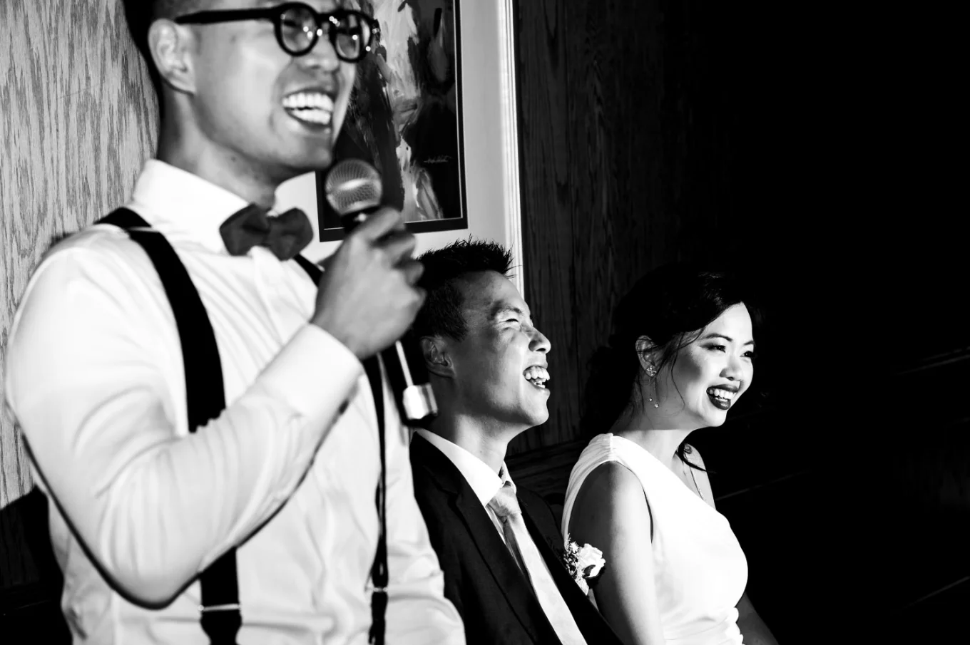 photograph of the batsman giving a speech. Newlyweds laugh. Moment captured by Banff Wedding Photographers.