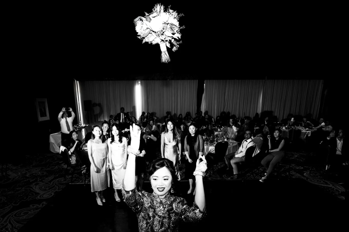 Bouquet tossing while all the single ladies try to catch the flowers during banff wedding reception.