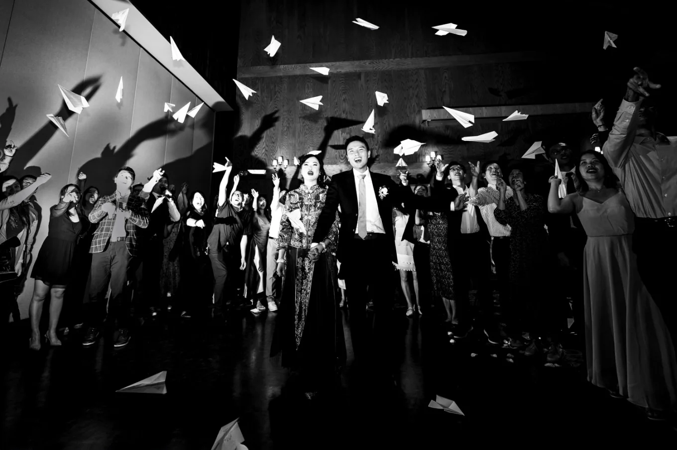 bride and groom walk while the quests through the paper planes. Creative photograph taken by Banff Wedding Photograph.