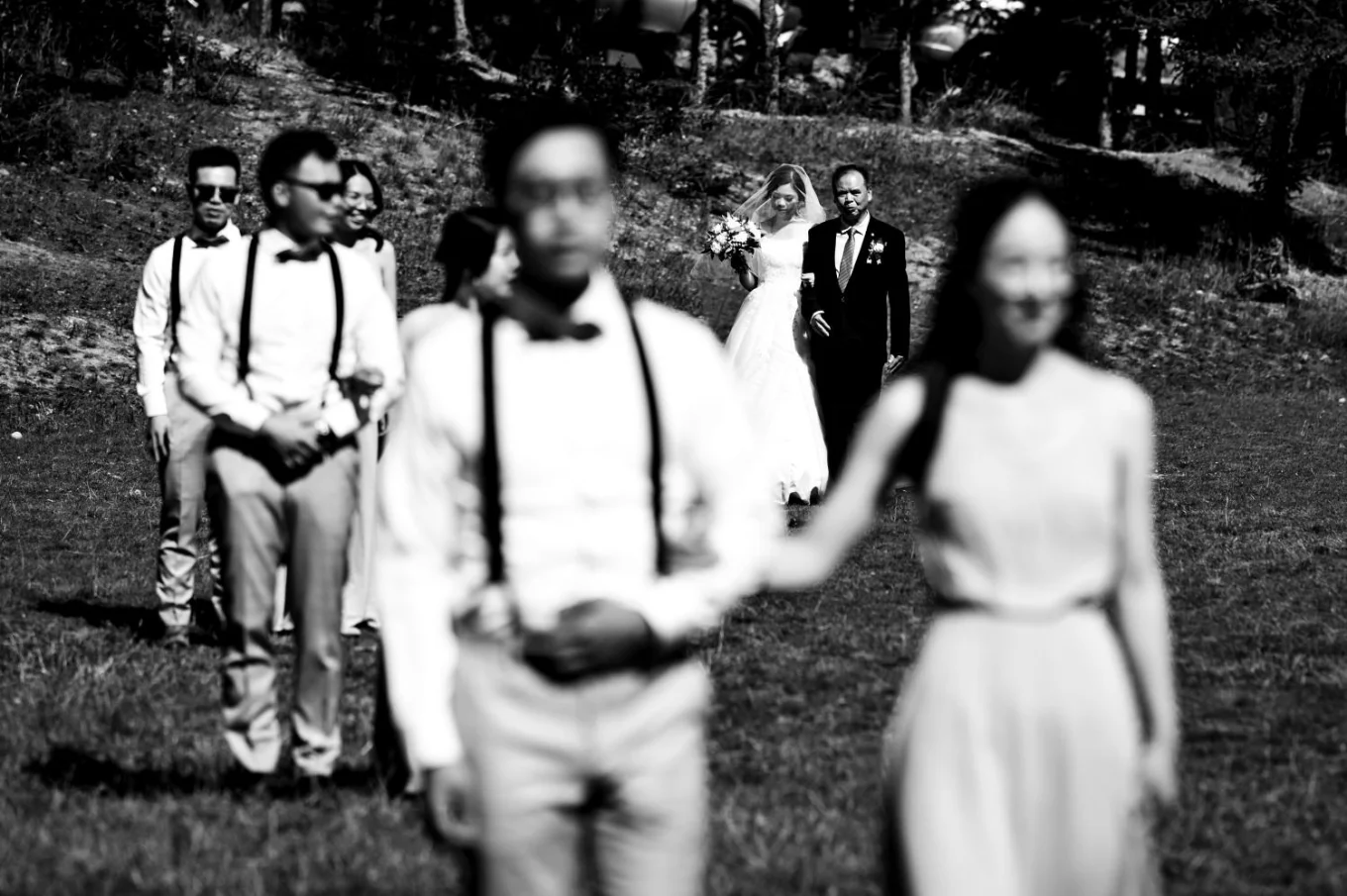Wedding party and bride and groom walk on the aisle at the wedding ceremony at Tunnel Mountain in Banff. Photograph in black and white taken by Banff Wedding Photographer.