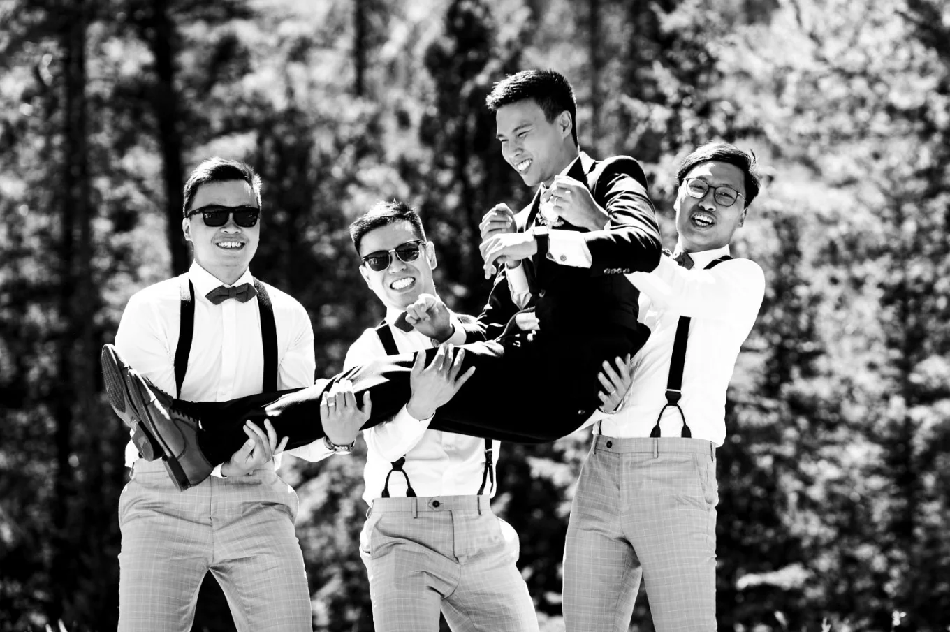 Funny Banff Wedding Photograph of the wedding party lifting the groom on their hands.