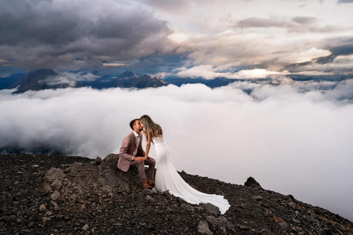 Wedding couple embracing in front of breathtaking Canadian Rocky Mountains during a photoshoot.