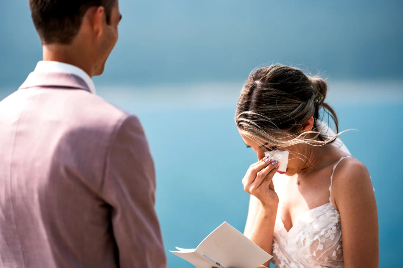 Bride wipe her chick as she cries during reading the vows. Emotional moment captured by Banff Wedding Photographer.