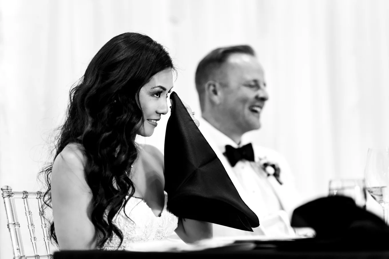 The bride wipes her cheek as she cries during the wedding speaches
