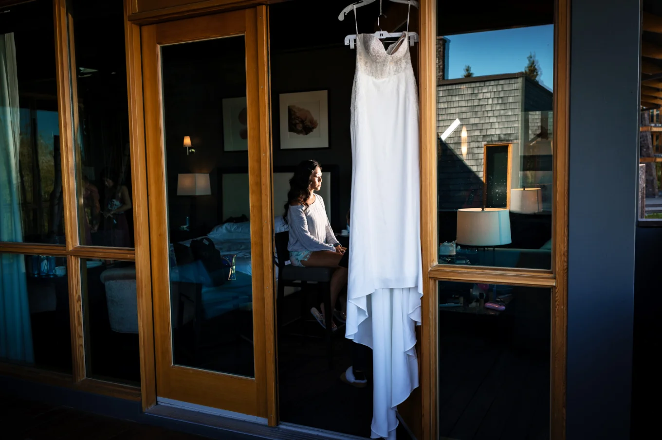Calgary Wedding Photography of the wedding dress hanging at the widow and the bride having make up done