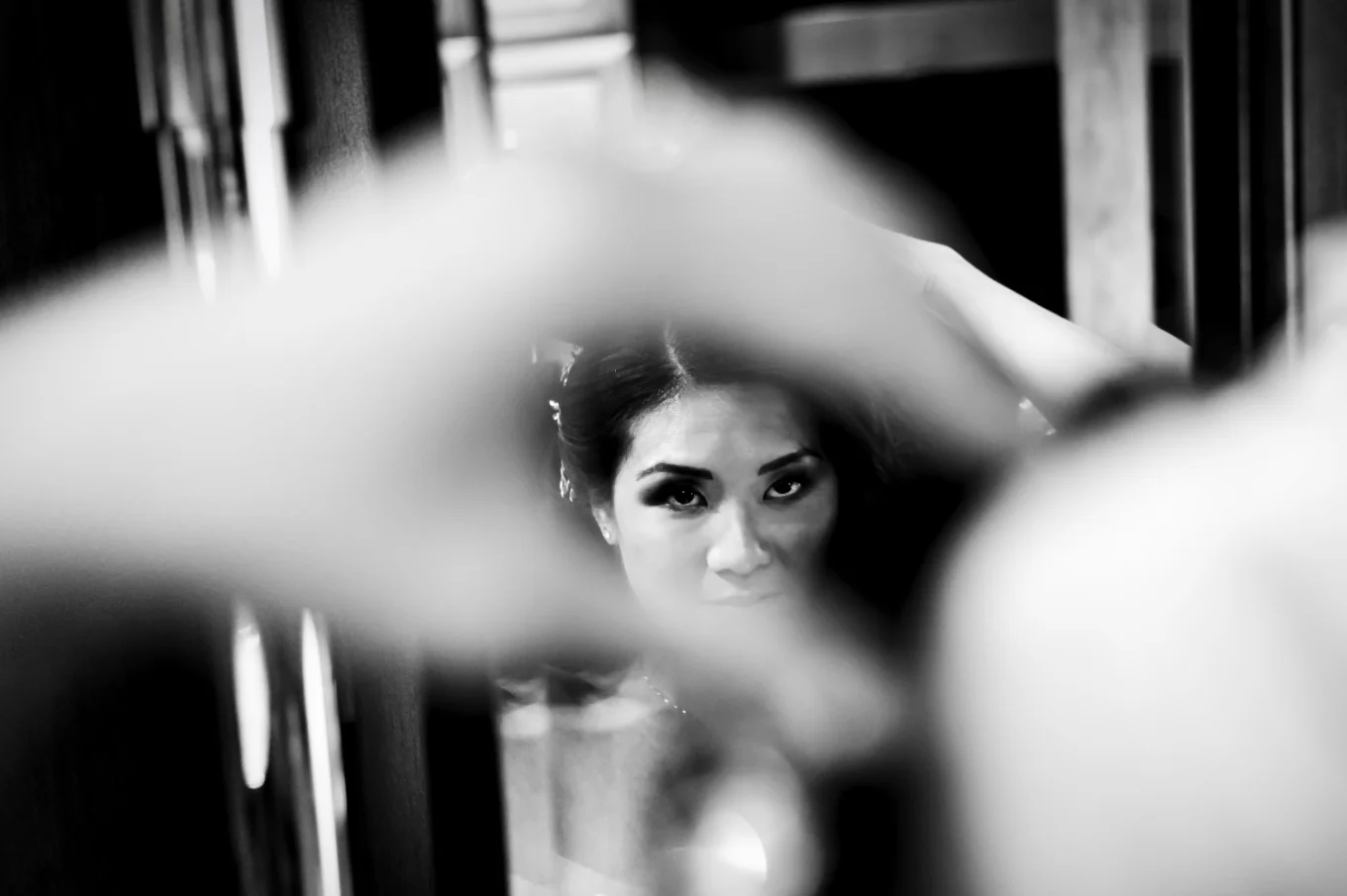 Black and white photography of the bride fixing her hair