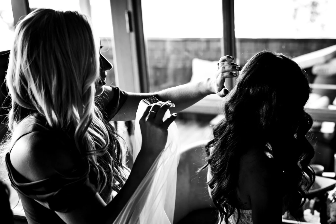 Canadian wedding photography of the hairdresser putting veil on the bride