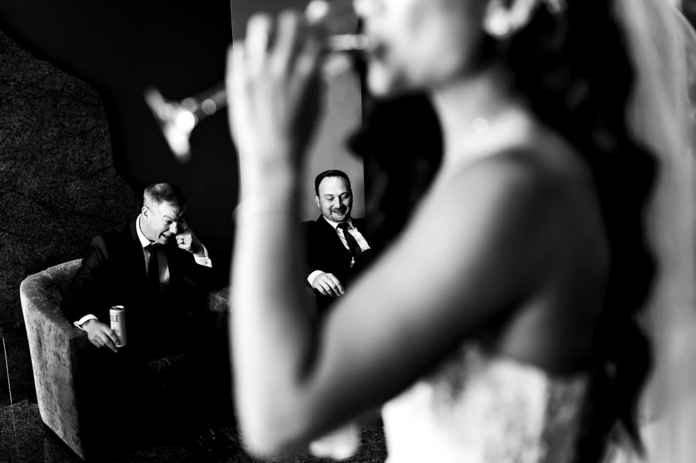 shoot through of wedding guests in Calgary looking at the drinking bride