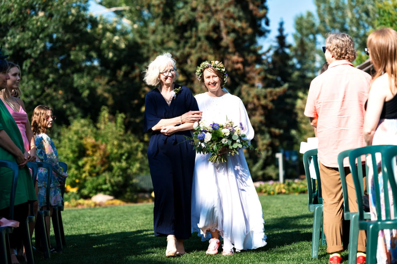 Mather of the bride walks the bride down the aisle.
