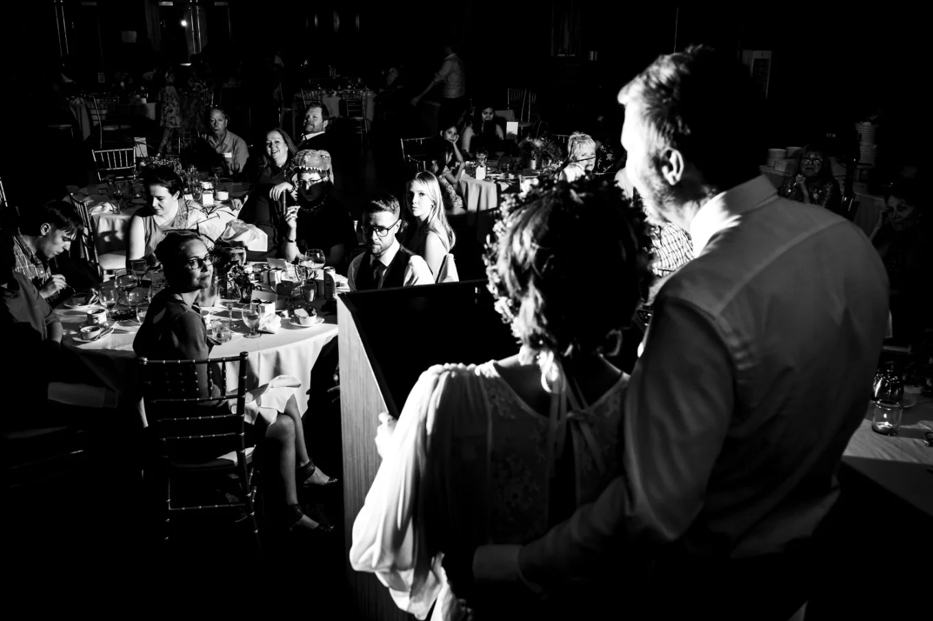 Calgary Wedding Photography of the bride end groom giving a speech. All the guests are listening.
