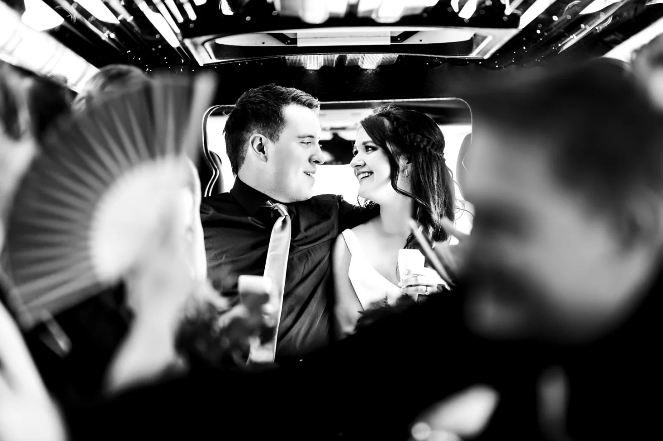 Newlyweds look at each other in the limo