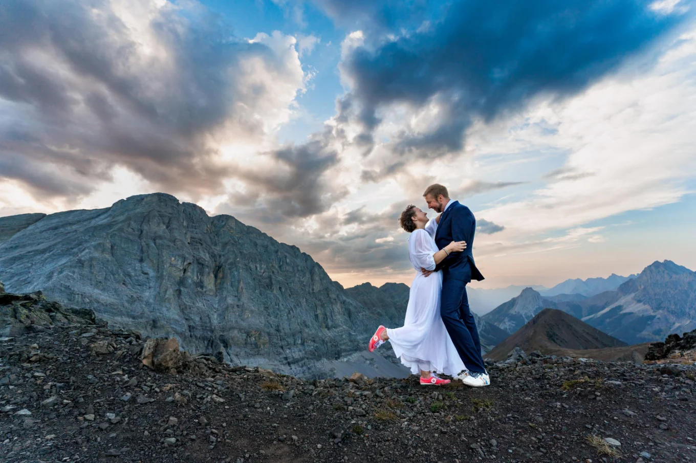 Bride and groom facing each other and look into their eyes during stunning sunset in Banff