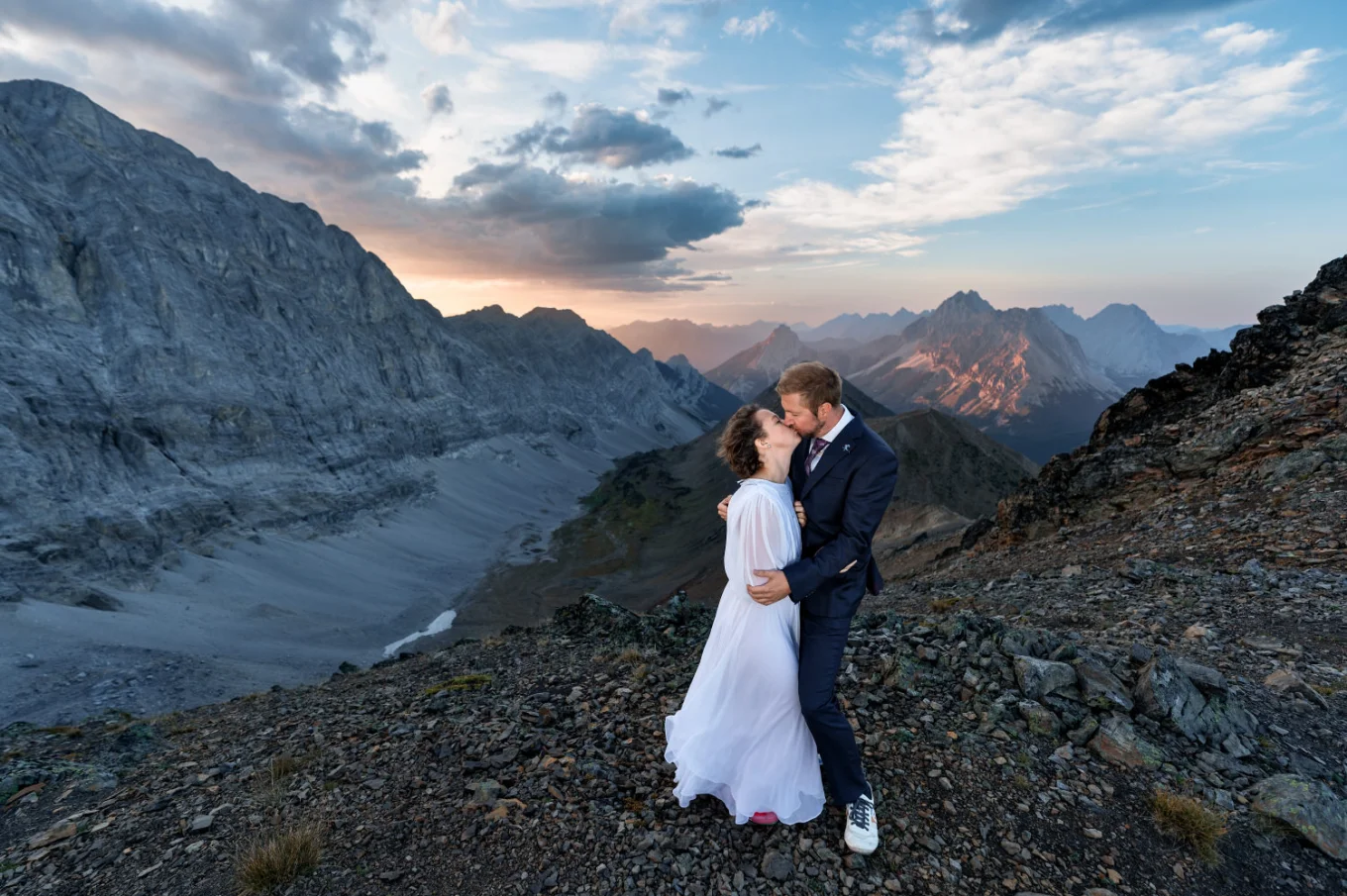 a first kiss of the newlyweds at Pocatera Ridge duting Banff Wedding Adventure