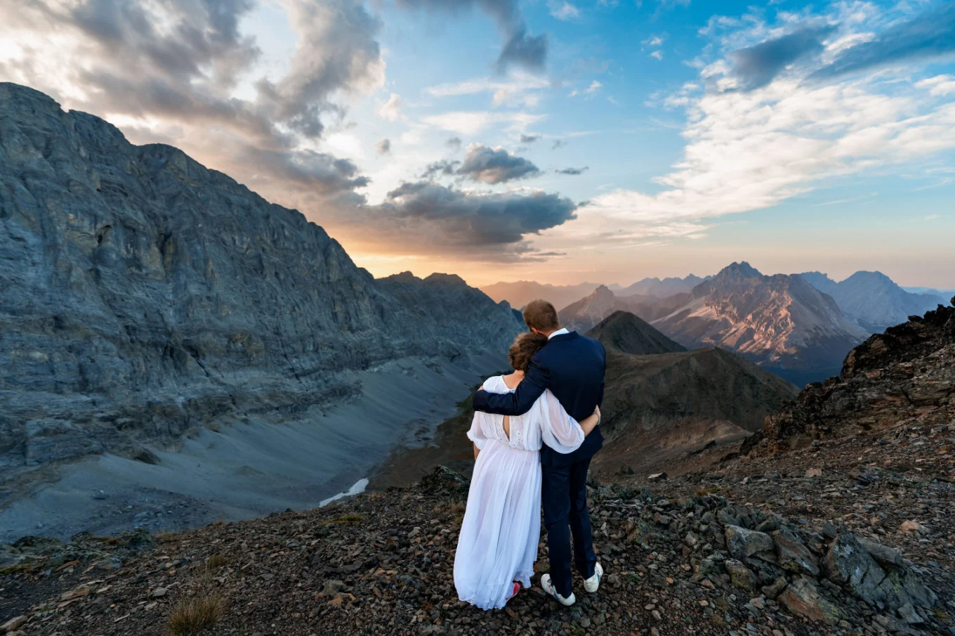 Bride and groom in a hug looking at the stunning sunset in the Canadian Rockies