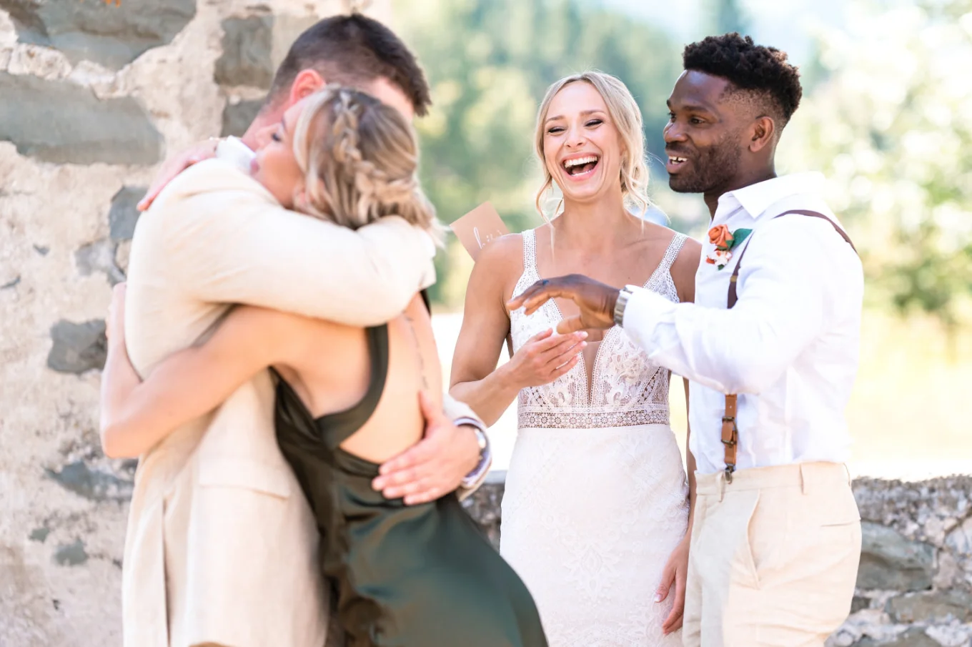 groom hug his sisster while the bride and best men siles.