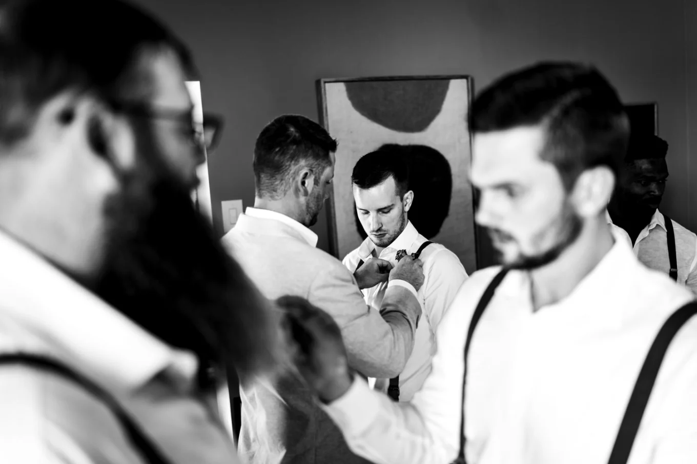 Gentelmen get ready for thr Waterton wedding. They fix their ties.