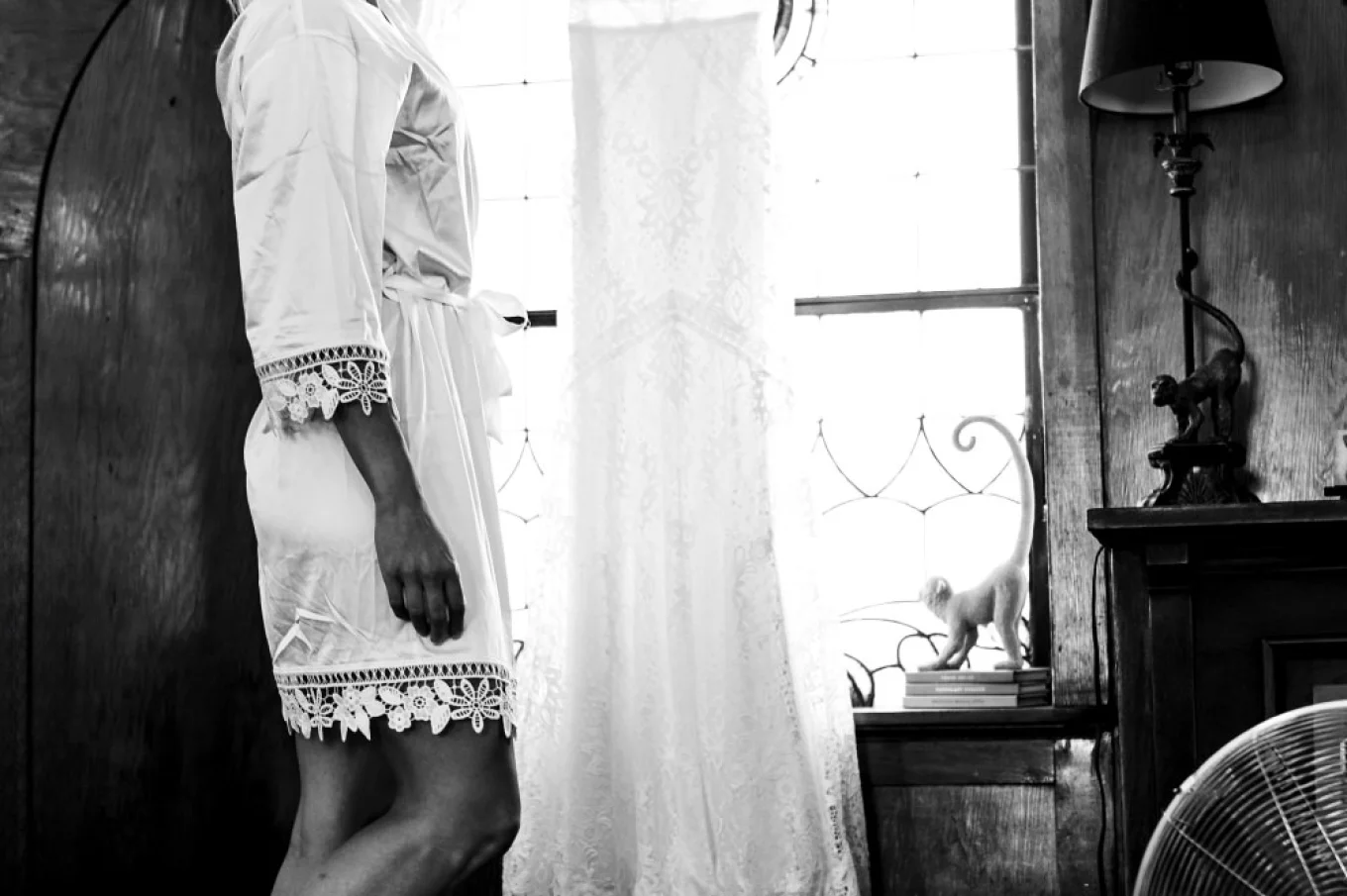 Bride reaches for her wedding dress before getting ready.