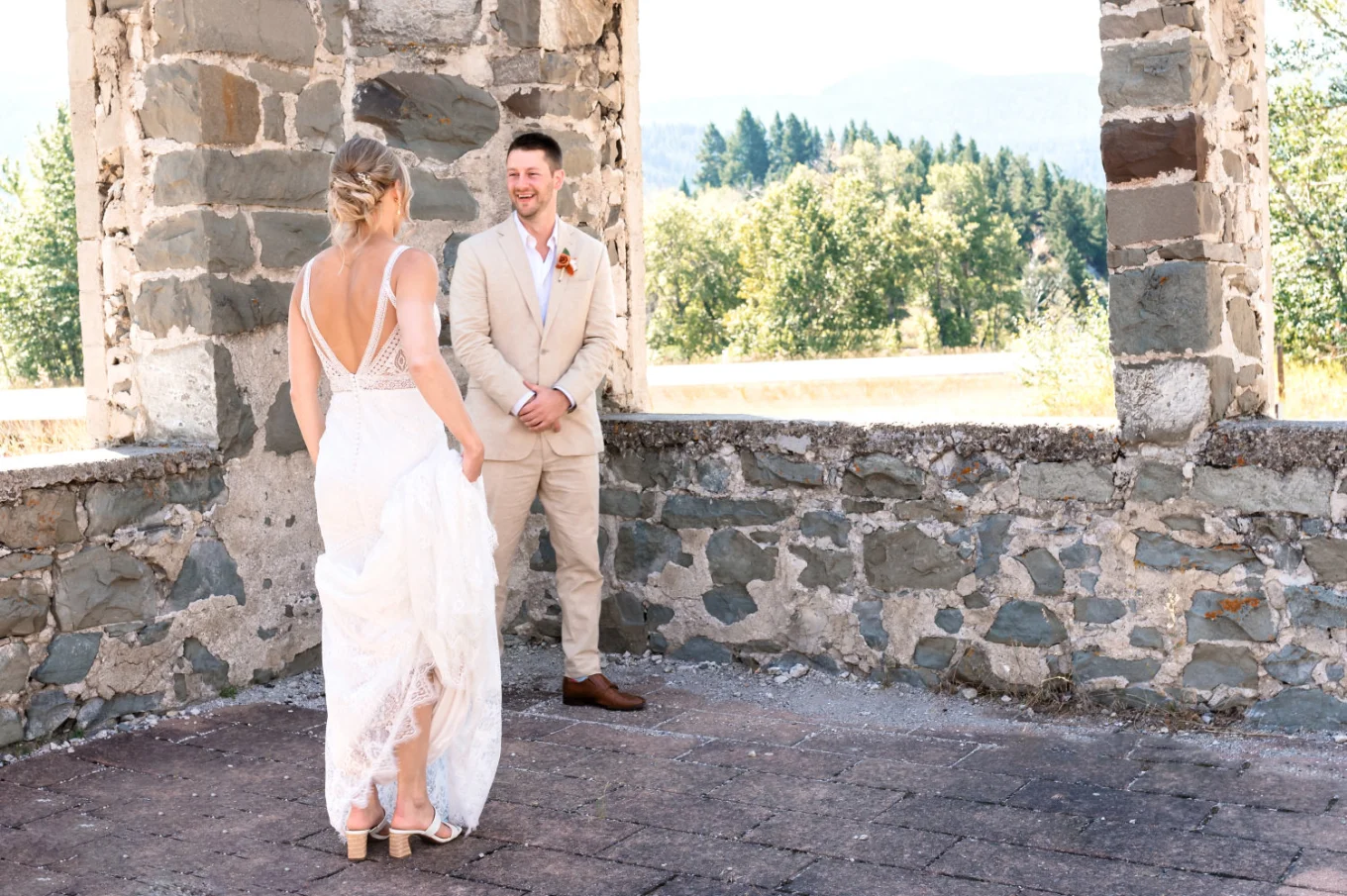 First look of the groom on the bride. He's smiling while she's walkin to him.