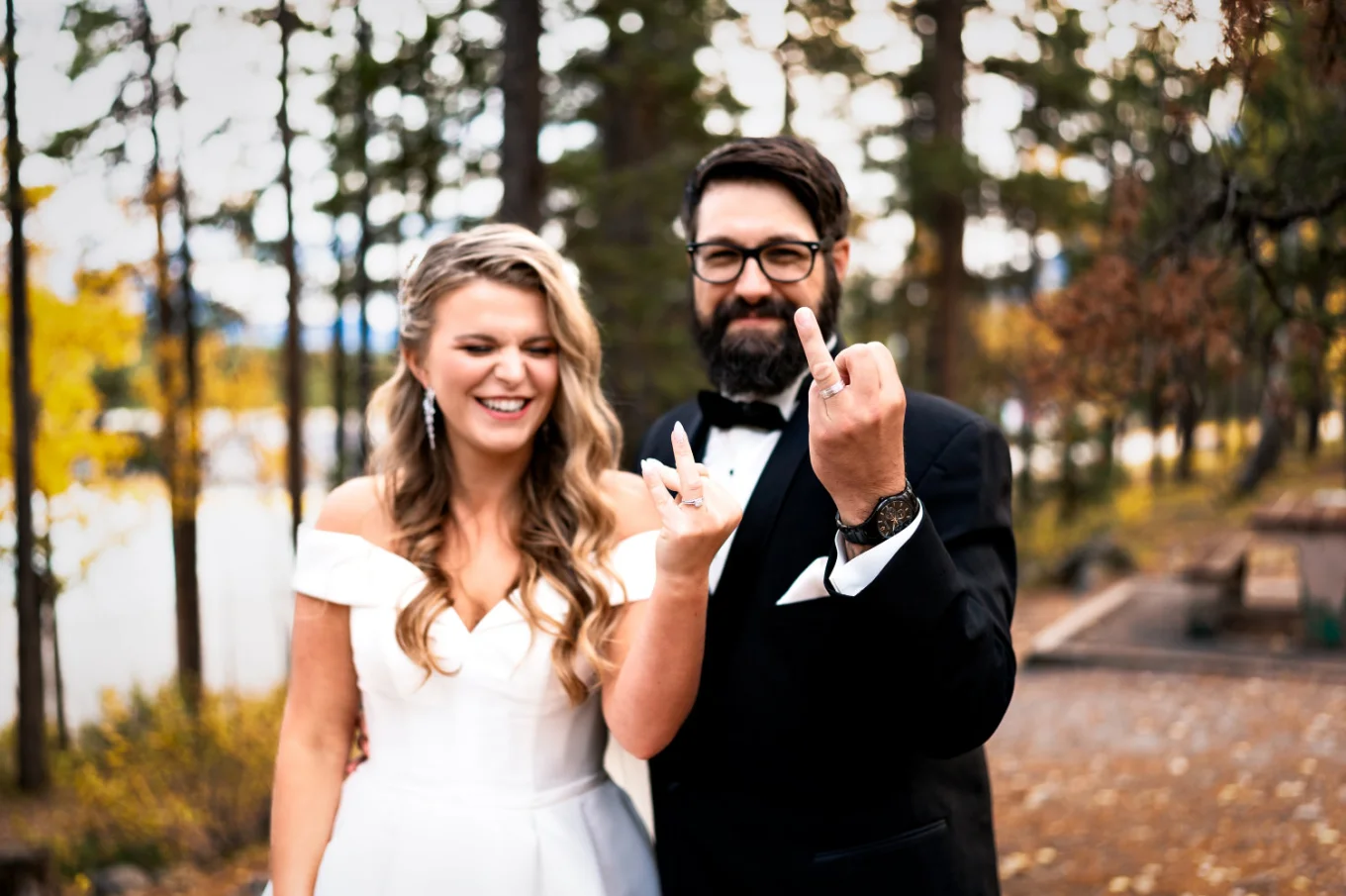 Bride and groom point their fingers with the wedding rings