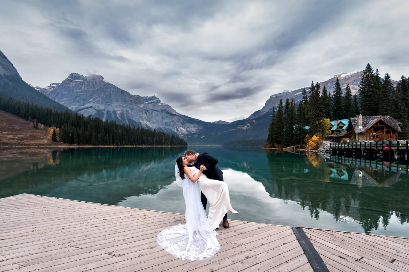 Wedding dip of the bride and groom at Emerald Lake .