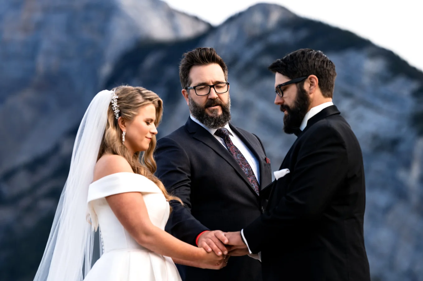 Priest gives a blessing to newlyweds at Banff Elopement Ceremony.