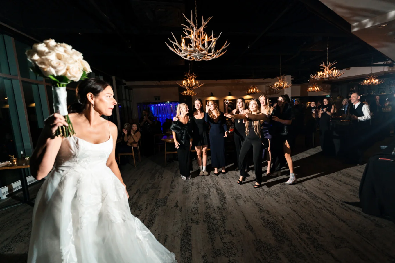 The bride troughs the bouquet while single ladies try to catch it