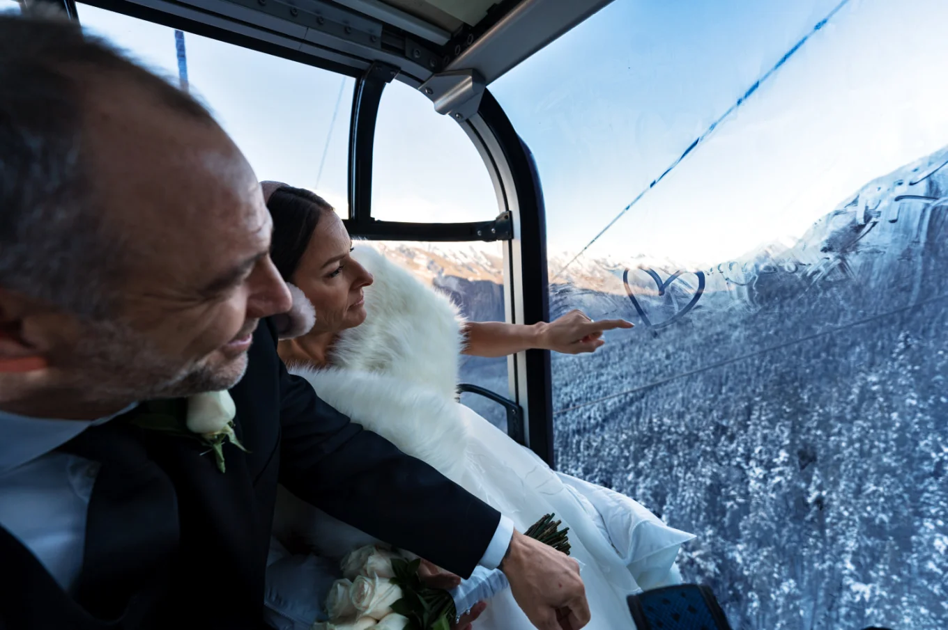 bride draw a heart on the window in the ski lift in Banff