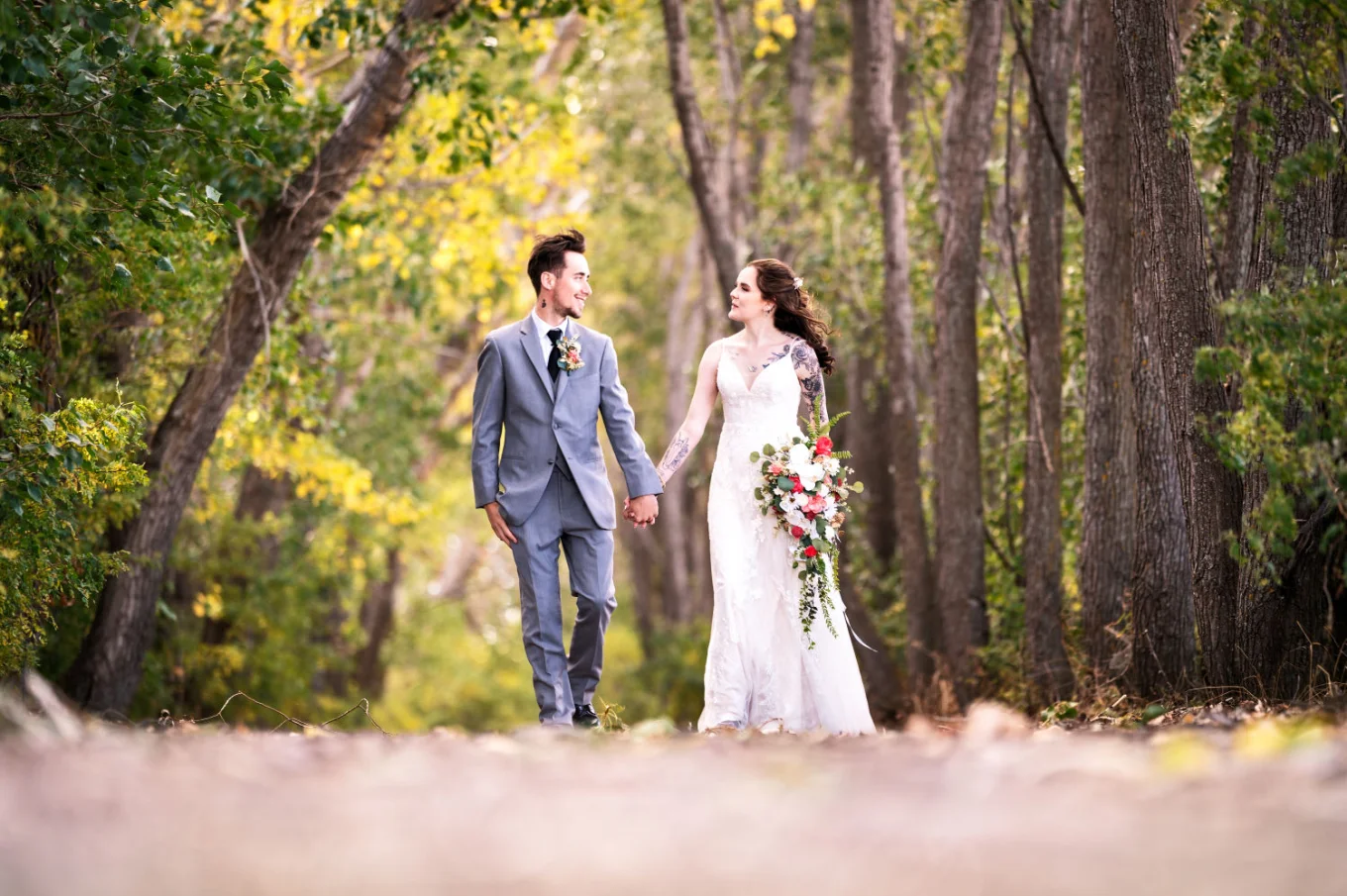 Calgary Wedding Photograph of the bride and groom walkin in the forest