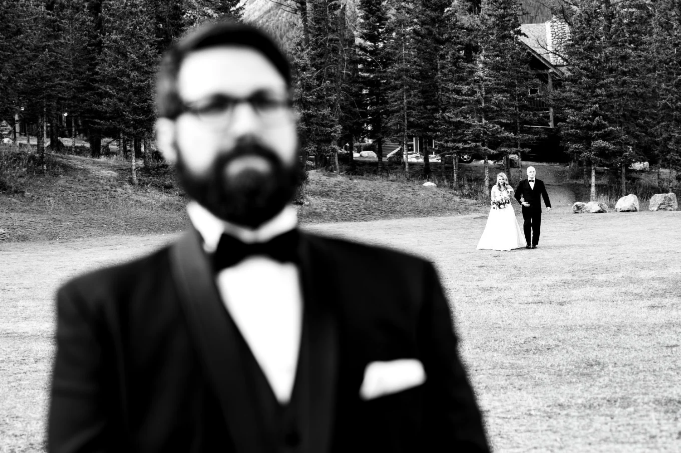 groom waits while the bride and her father walk down the aisle.
