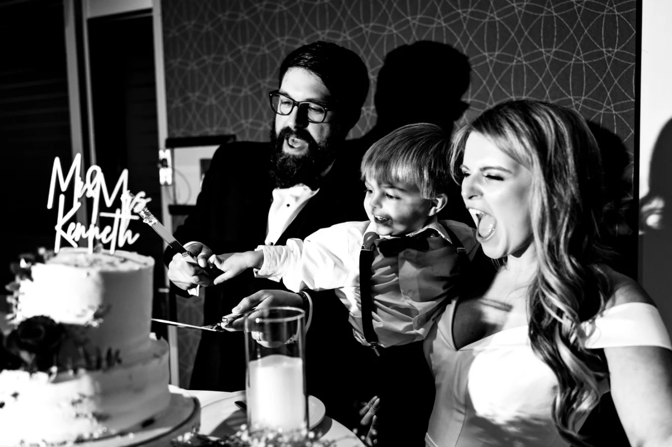 Bride, groom and their son cutting the wedding cake in Edmonton.