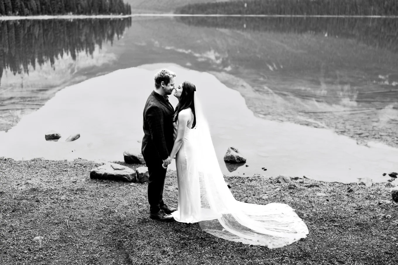 Black and white wedding portrait of the bride and groom facing each other by the Emerald Lake