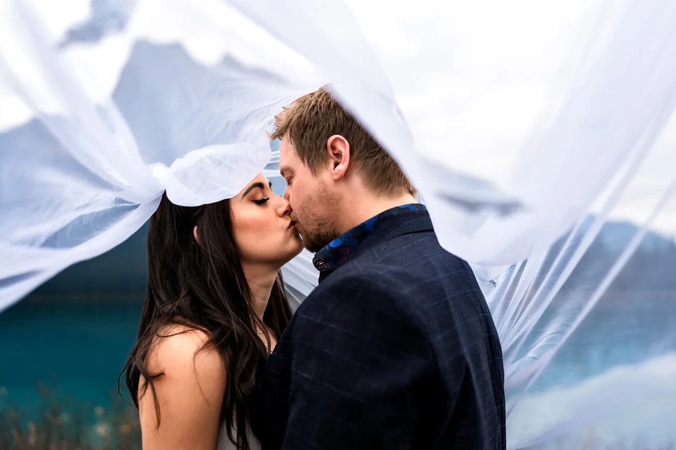 Bride and groom share a kiss under the veil