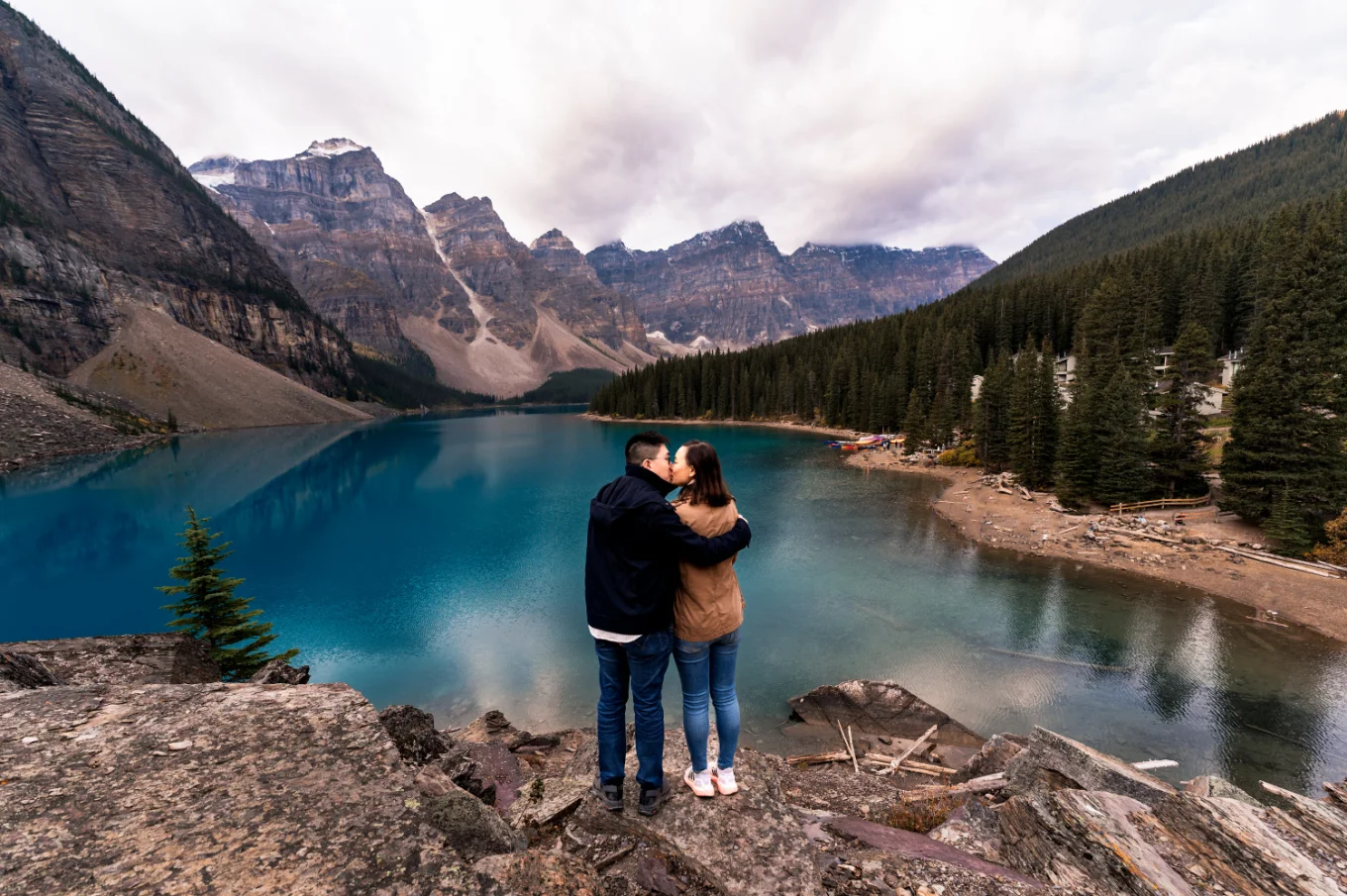 Couple in love adore the view of blue water at Moraine Lake