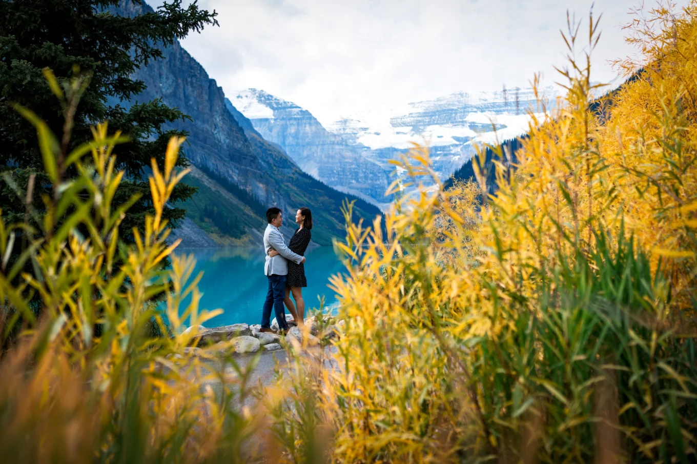 Shoot through yellow grass of the couple in a hug