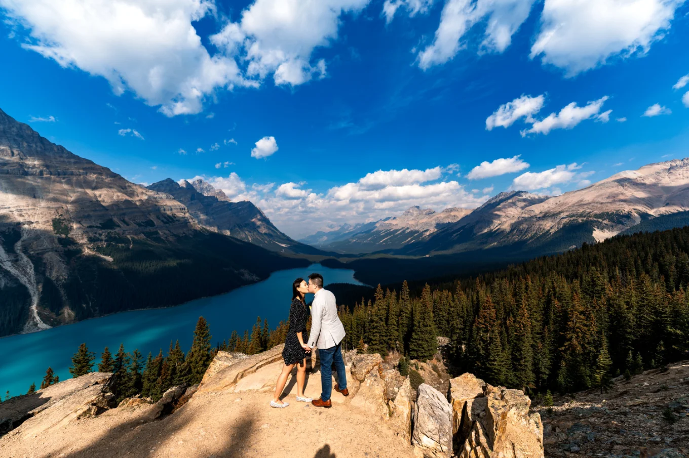 Engaged couple share a kiss at Peyto Lake in the mountains