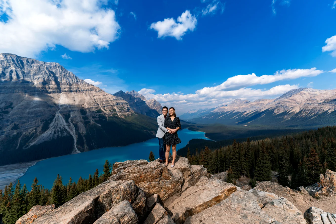 Men hugs his fiance from behind at blue peyto lake in Banff National Park
