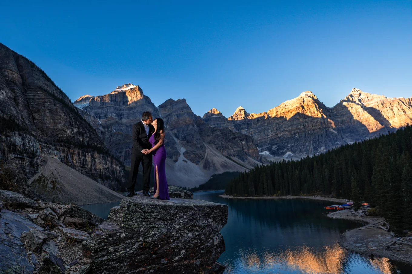 Well dressed couple standing at the rock at Moraine Lake.