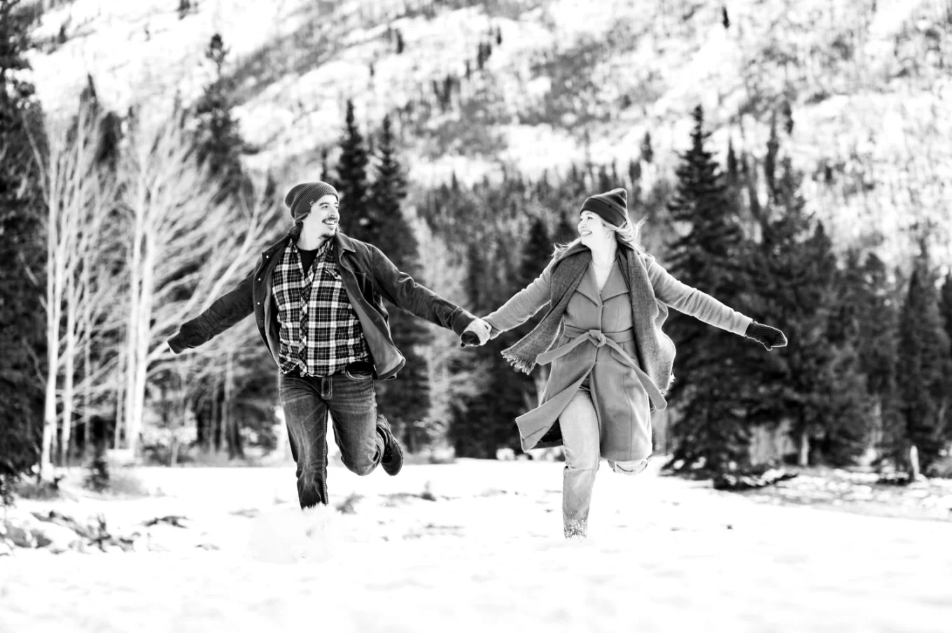 Man and lady run in a deep snow in Banff.
