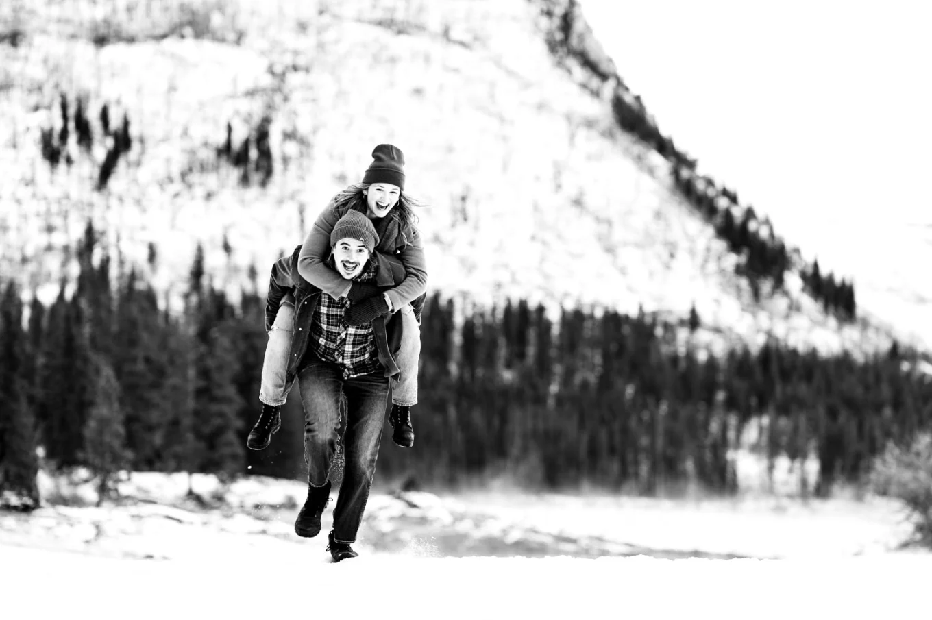 Fun engagement moment of the man running with his fiancee on his back.