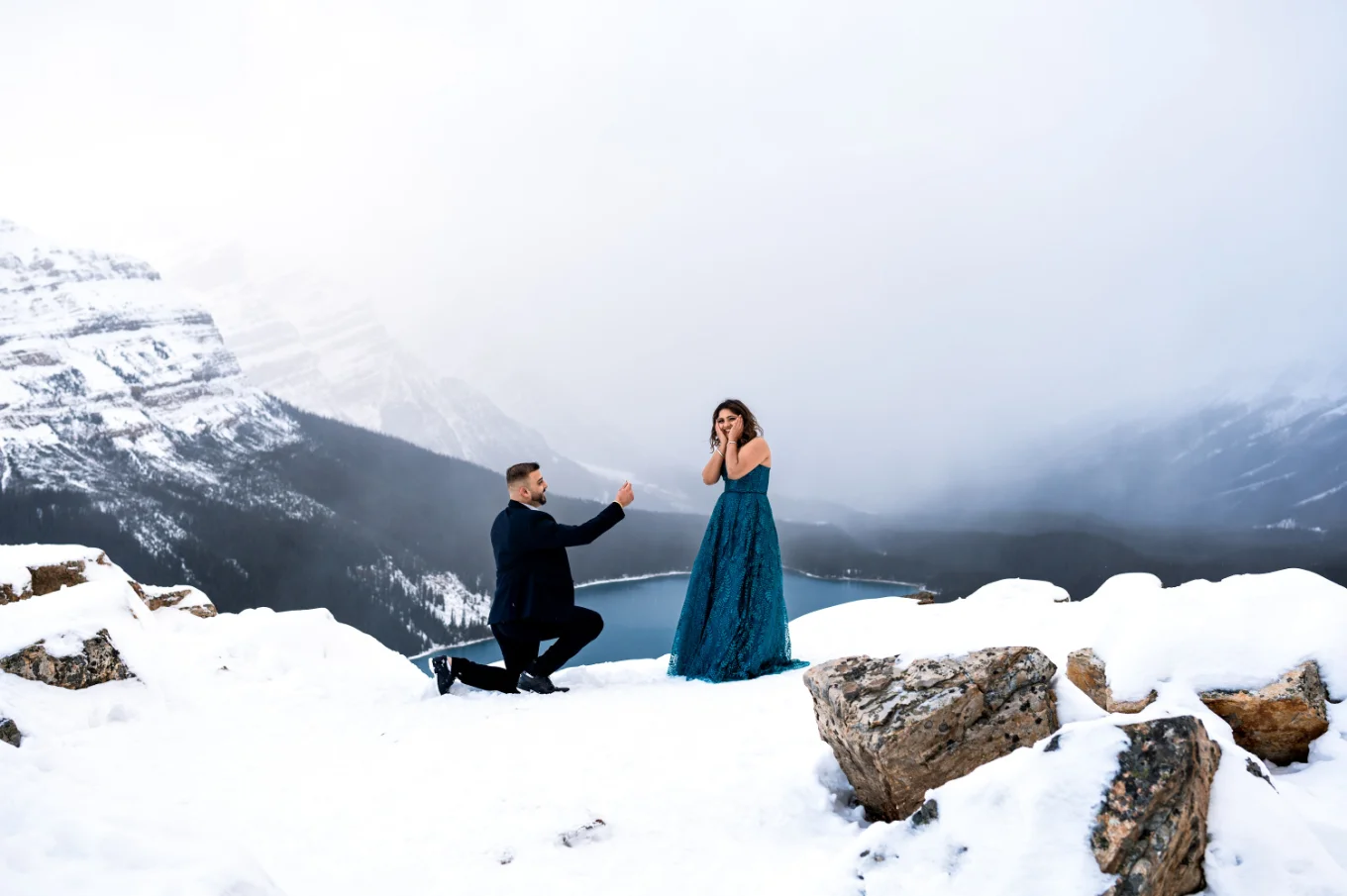 Man goes down the knee with the engagement ring and propose in the Canadian Rockies
